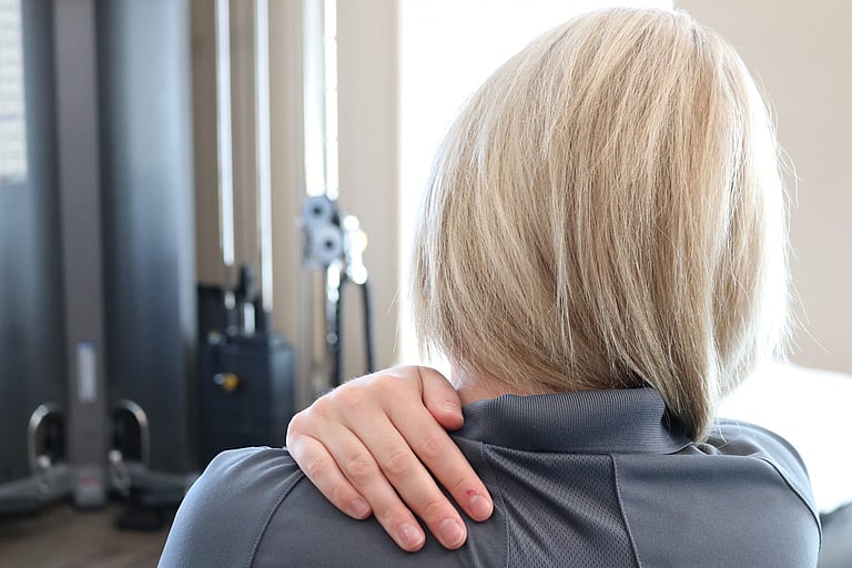 Patient demonstrating self mobilization on the neck to manage tension in neck and back muscles