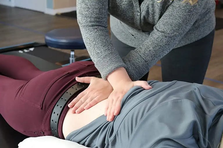 person getting visceral fascial mobilization treatment on their back
