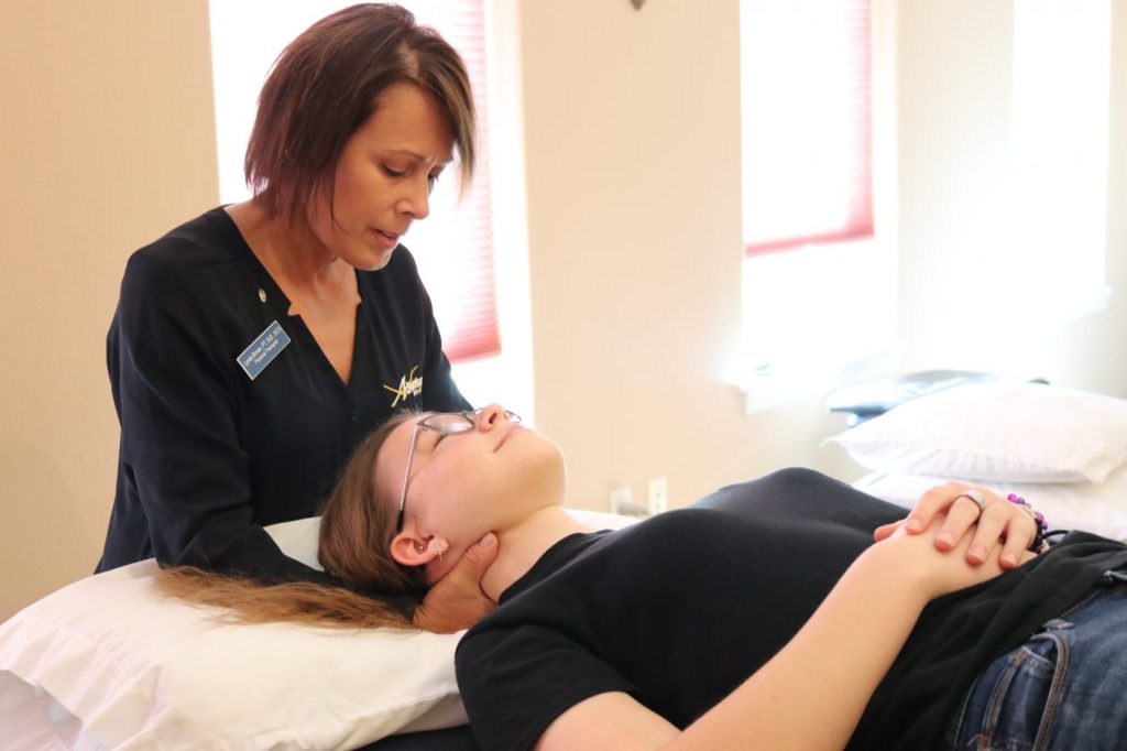 Therapist putting manual traction on the patients neck creating space in the neck muscles in order to help relieve tension