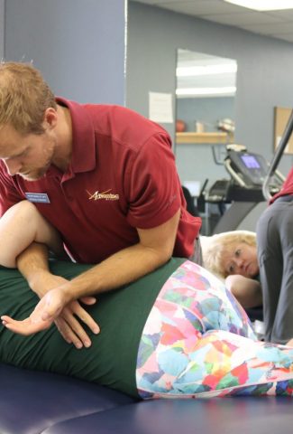 Powell Wyoming therapist appllying pressure to the patients back and hip to help ease pain in the targeted area